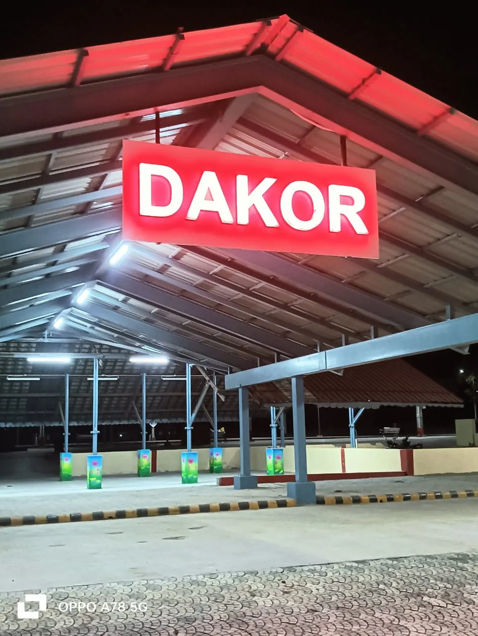 Dakor railway station platform under lit canopy